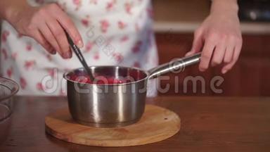 靠近一个带有水果糖浆的平底锅，用勺子搅动厨师